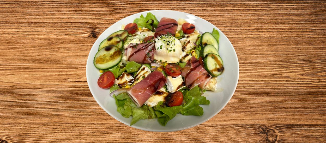 Salade à base de brie de Meaux, jambon cru et œuf poché.